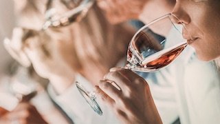 Eine Gruppe genießt Wein, während sie elegant aus Gläsern trinken.