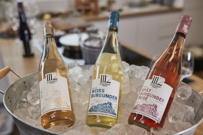 Die Flaschen zeigen die Weinsorten: Blanc de Noirs, Weißburgunder und Spätburgunder Rosé, perfekt gekühlt im Eis.