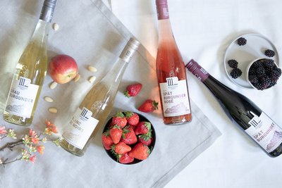 Die Anordnung von Weinflaschen und frischen Früchten schafft eine einladende Atmosphäre für eine gesellige Zusammenkunft.